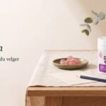 Kollagen: sammenlign før du velger. Boks med kollagen-vingummi, rosa vingummi i en olivengrønn skål, et blankt kort og en blyant på linduk i dagslys.